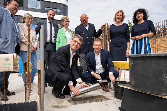 Im Vordergrund: Michael Baumann; Vorstandsvorsitzender DKFZ, Michael Kretschmer, Ministerpräsident des Freistaates Sachsen. Im Hintergrund v.l.n.r.: Frank Ohi, Kaufmännischer Vorstand des UKDD, Angela Rösen-Wolff, Prorektorin Forschung der TU Dresden, Sebastian Gemkow, Staatsminister für Wissenschaft, Kultur und Tourismus, Ursula Weyrich, Kaufmännischer Vorstand des DKFZ; Michael Albrecht, Medizinischer Vorstand des UKDD, Esther G. C. Troost, Dekanin der Medizinischen Fakultät der TU Dresden, Stefanie Speidel, Gründungsdirektorin DKFZ Standort Dresden