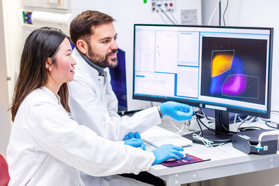 Two scientists looking at a computer monitor